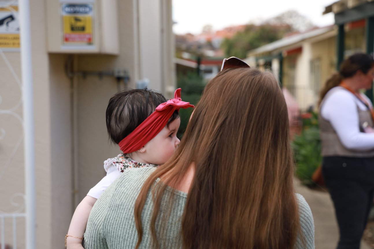 A portrait of a mother and child from behind.