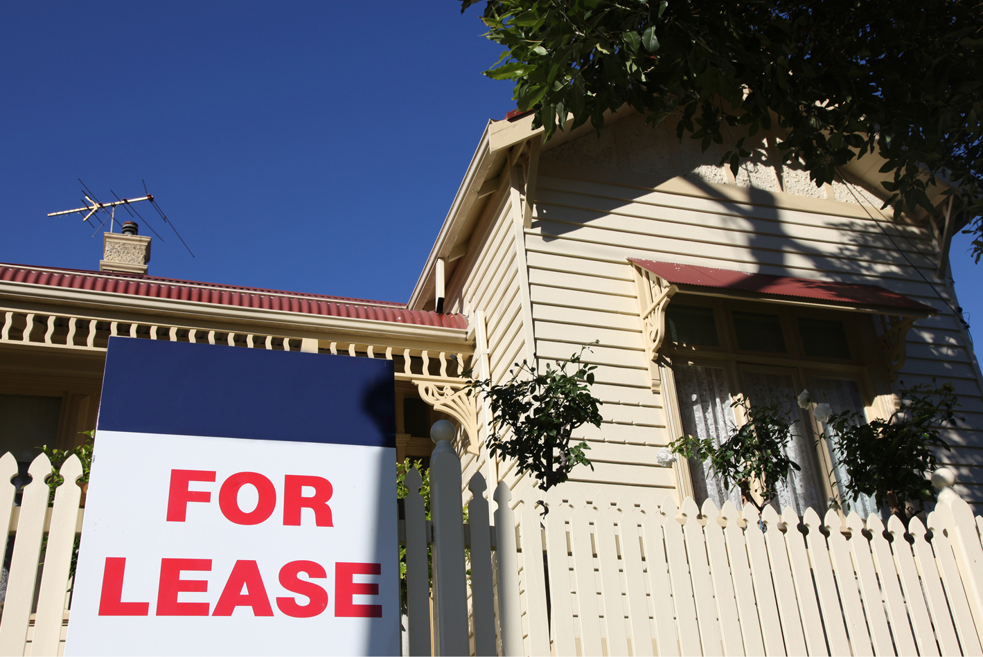Picture of a house with a for lease sign out the front of it