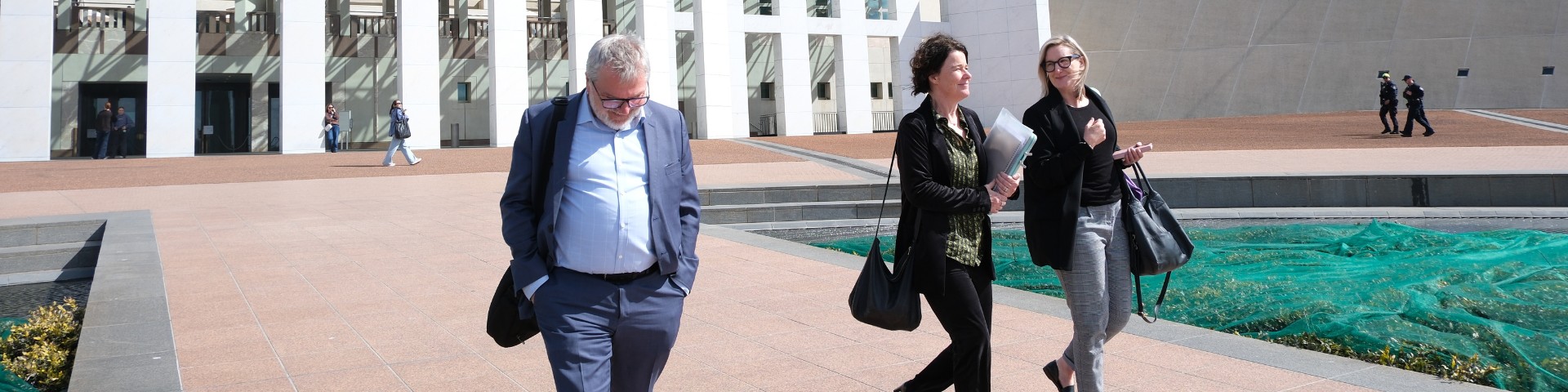 Mark Glasson and Sarah Kane walking away from Parliament House smiling.