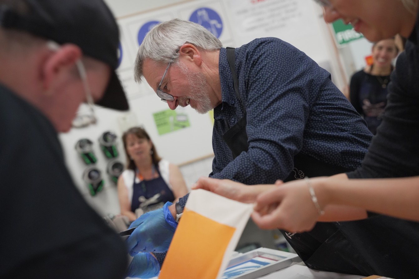 CEO Mark Glasson screen printing canvas prints at Northbridge TAFE.