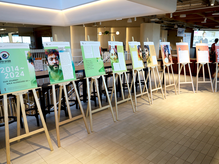 10 large canva's with images and text of them sitting on easels which are lined up. The closest board has 2014-2024, celebrating 10years of impact written on it, which is about an Anglicare WA service