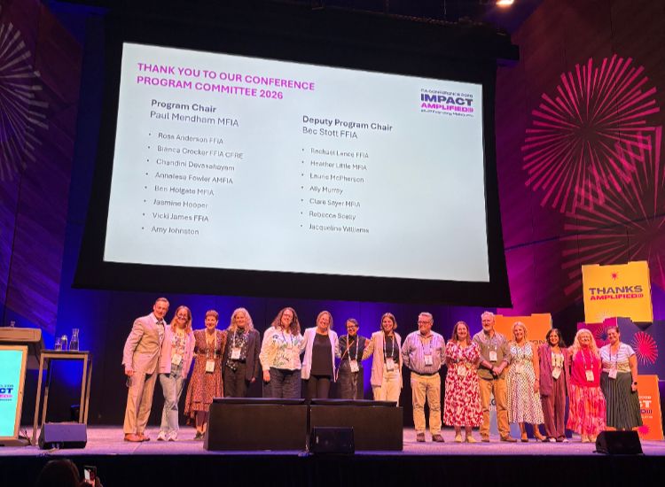 Members of our Philanthropy team stand on stage at the FIA Conference 2026.