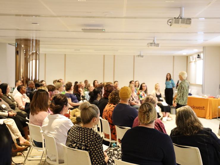 A large group of people sitting watching a presenter