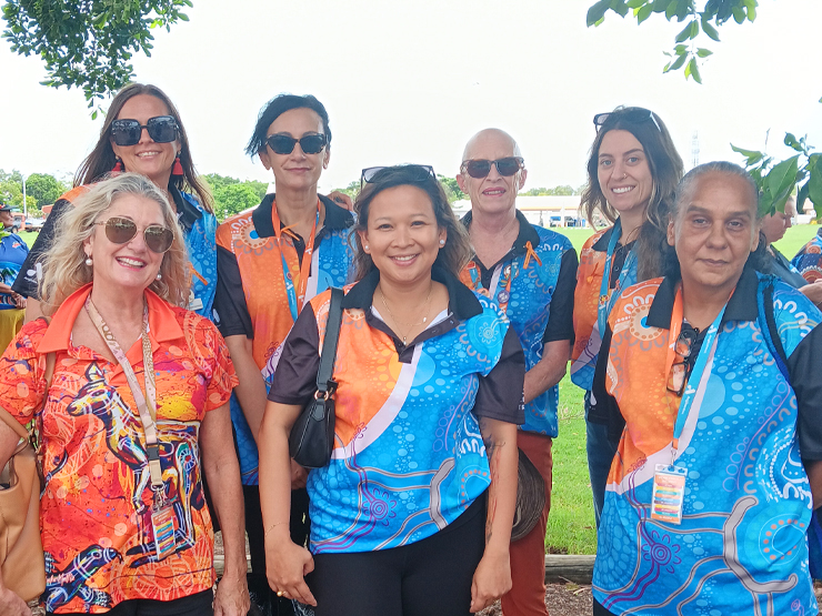 A group of seven Anglicare WA workers smiling at the camera for a group photo at a community event.