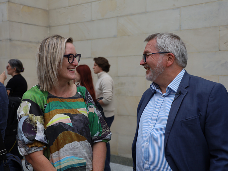 Two people standing talking to each other outside Parliament House in WA