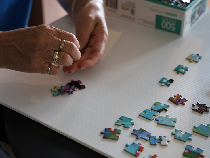Close up picture of a lady's hands doing a puzzle