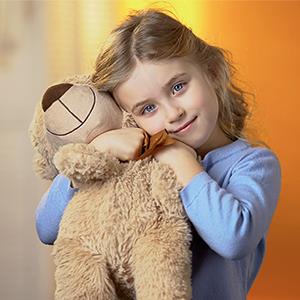 Anglicare WA -Young Hearts Domestic Violence Support A picture of Daisy with a teddy bear, feeling happy and safe.