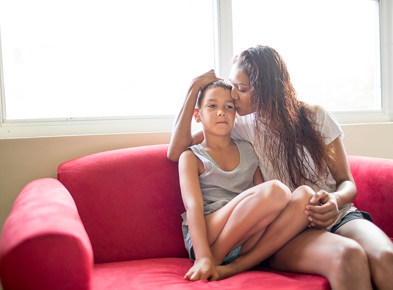 Aboriginal mother and son sitting on couch